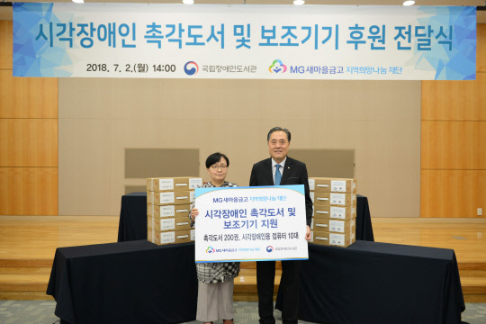 박차훈 MG새마을금고 지역희망나눔재단 이사장(오른쪽)이 정기애 국립장애인도서관장과 기념촬영을 하고 있다.  MG새마을금고 제공